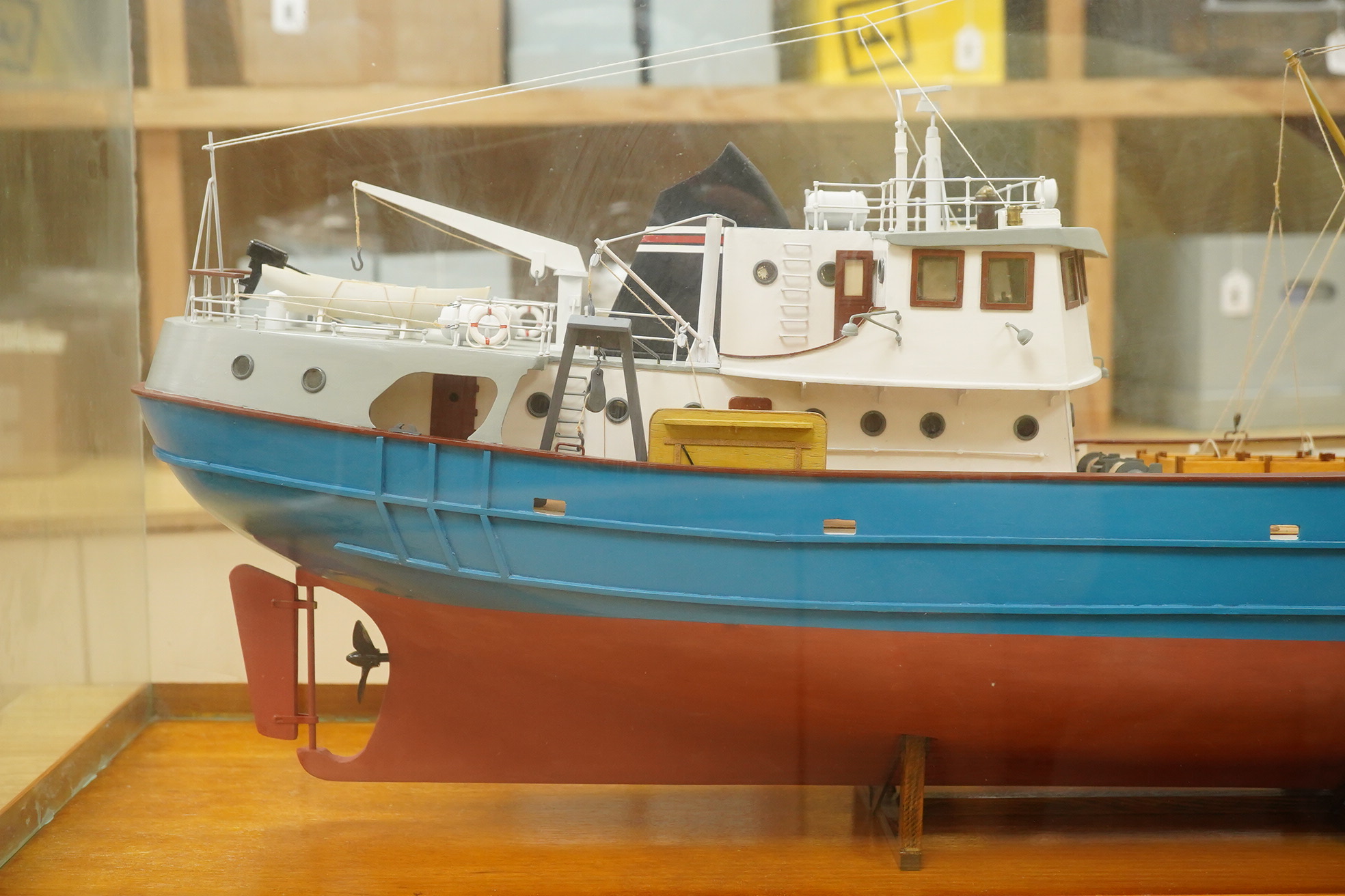 A model of a fishing trawler ship constructed from a kit by Billings Boats models, of painted wood construction, finished to a high standard with a good level of detail, presented in a glazed cabinet on a wooden base, ca